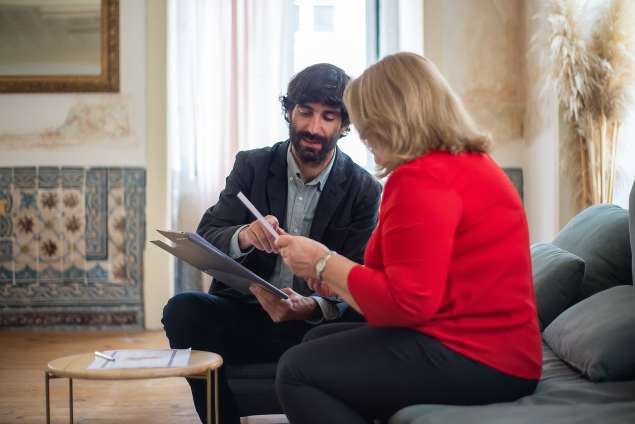 The Art of Drawing Readers In: Your attractive post title goes here A man and woman having a business discussion seated on a sofa in a stylish room.